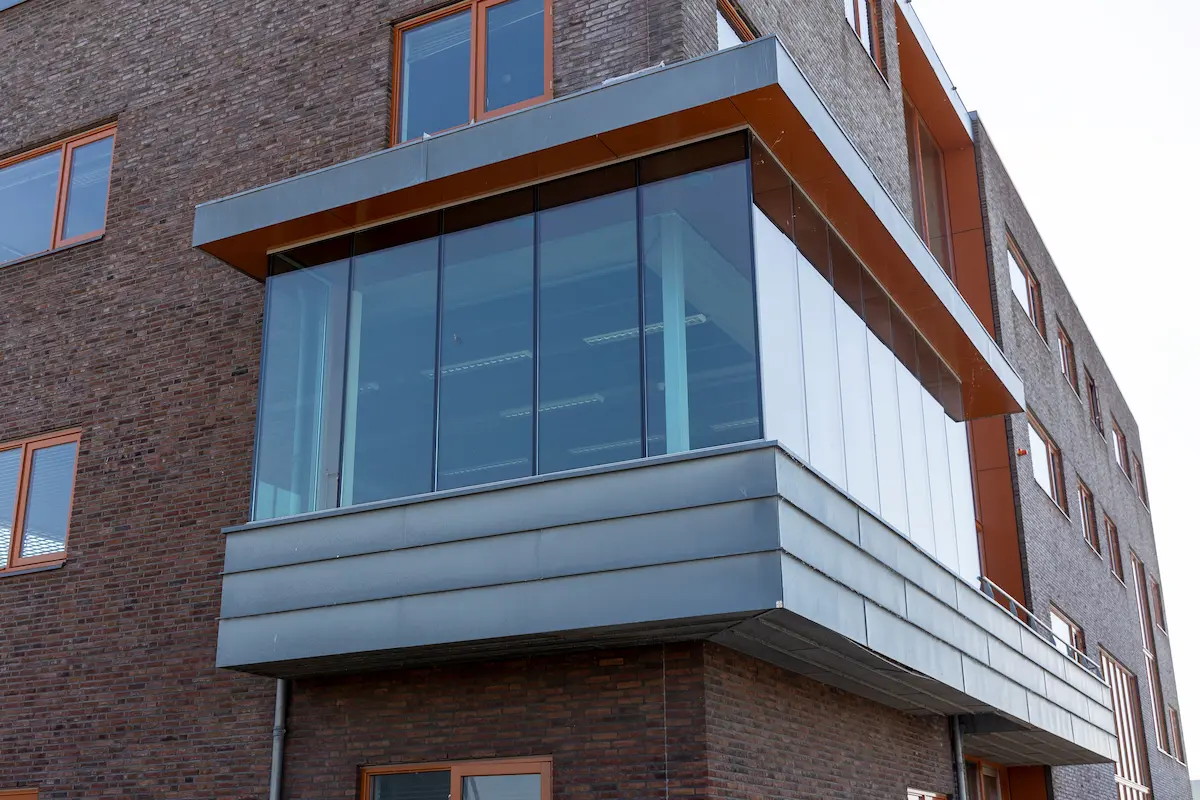 Uitkragende glazen erker met aluminium bekleding aan modern bedrijfsgebouw &ndash; strak en functioneel ontwerp door Bongers Architecten