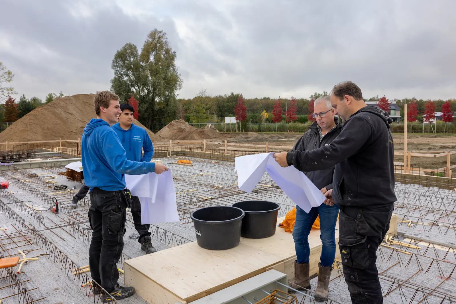 Overleg op de bouwplaats met de projectbegeleider.