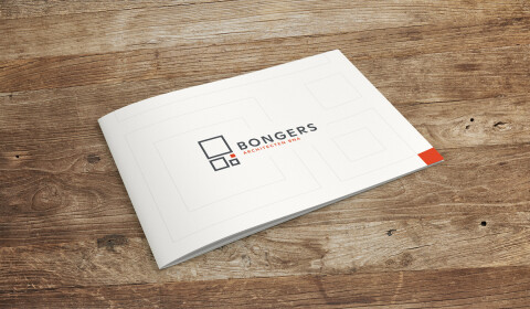 Brochure van Bongers Architecten met strak wit ontwerp en logo, liggend op een houten tafel.