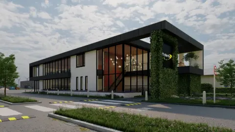 Modern duurzaam bedrijfspand met groene gevel en veel glas voor natuurlijke verlichting.