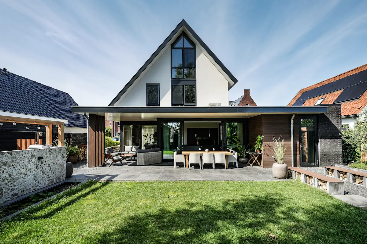 Moderne woning in Hendrik-Ido-Ambacht met brede glazen achtergevel, overdekt terras en sterke verbinding tussen woonruimte en tuin.