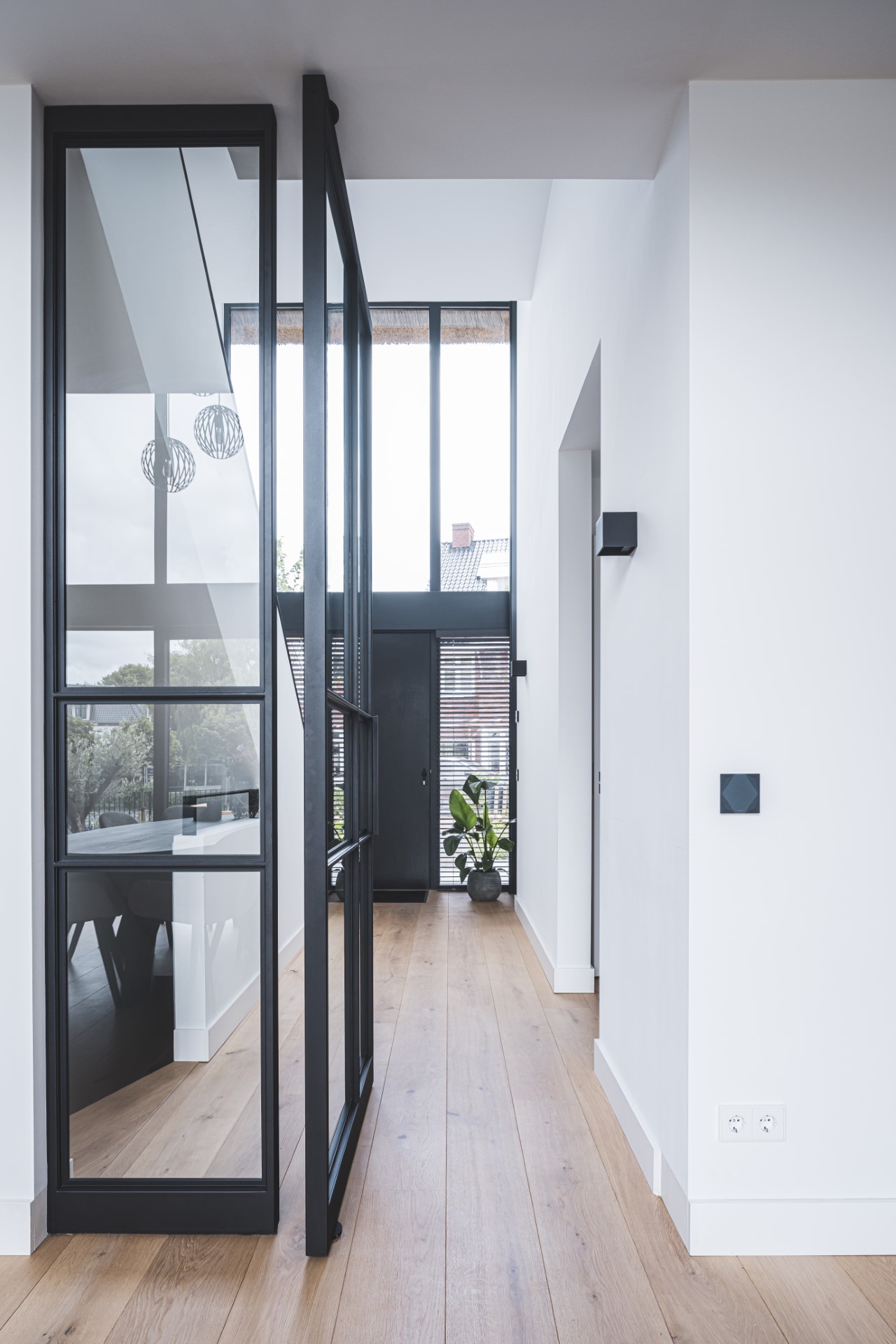 Strakke hal met stalen taatsdeur en vide in moderne villa &ndash; ontworpen door architect in Oud-Alblas