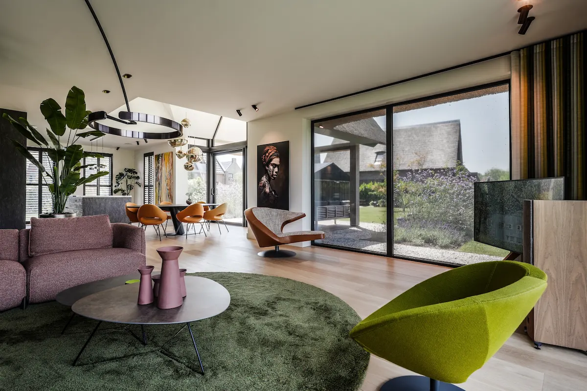 Lichte woonkamer met grote schuifpuien, open zichtlijnen en verbinding met de tuin in een moderne woning ontworpen door Bongers Architecten.