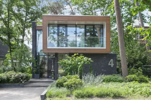 Moderne villa met zwevend houten volume, zwarte bakstenen gevel en grote glaspartijen – ontworpen door Bongers Architecten, architectenbureau in Nederland