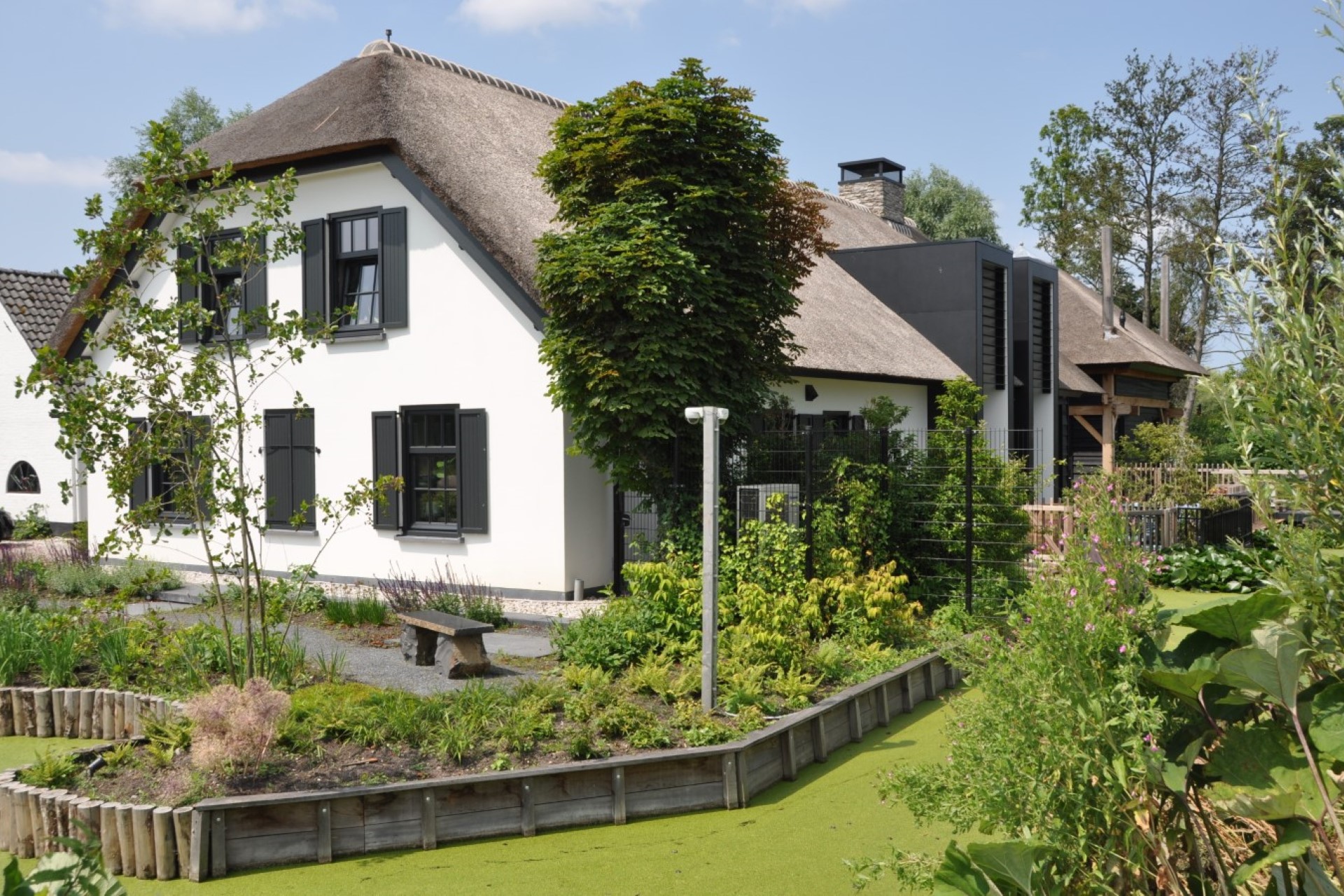 Verbouwing woonboerderij met wit stucwerk, rieten kap en moderne risaliet in antraciet &ndash; duurzaam huis ontwerpen door architect Oud-Alblas