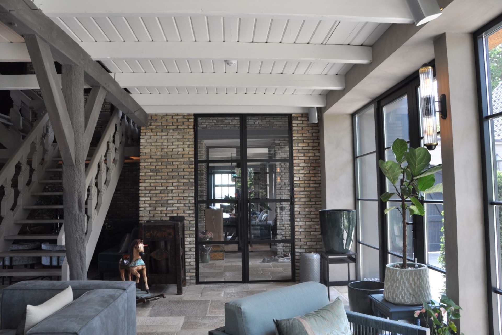 Maatwerk interieur in verbouwde woonboerderij met stalen deuren, houten balken en natuurstenen vloer &ndash; architect Oud-Alblas voor functioneel ontwerp